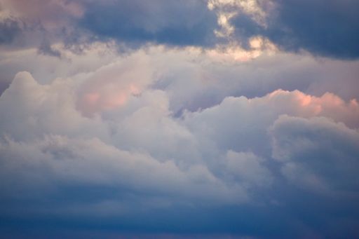 A beautiful view of puffy clouds like cotton wools in the purple-blue sky