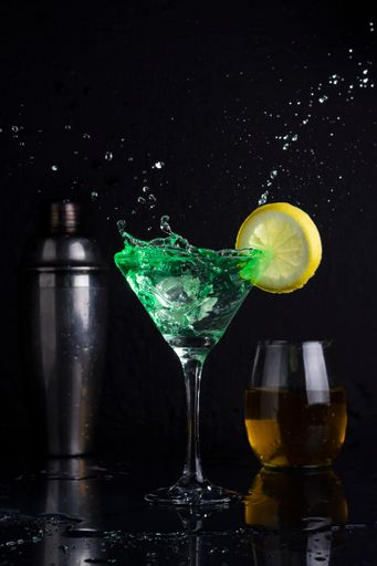 A vertical shot of a cocktail with lemon on dark background