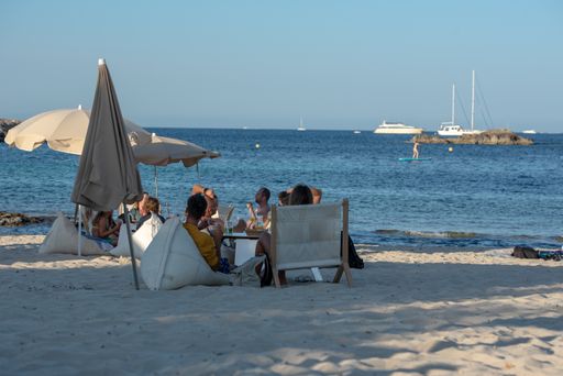 The people enjoying the Es Pujols beach in Formentera, Spain in the summer of 2021.