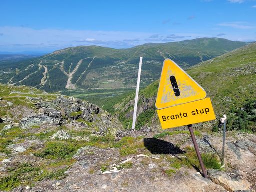 A closeup shot of a "Steep Slope" sign in the mountains of Northern Sweden