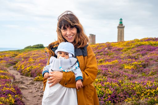 A young mother and her baby posing at the wildflower field near the Cap Frehel Lighthouse in  France