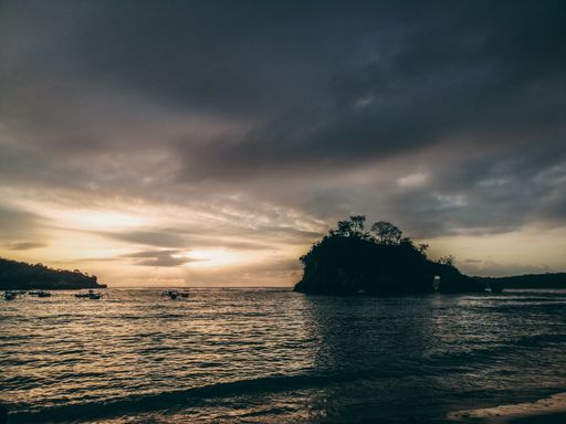A closeup shot of the seashore under a dark sunset sky