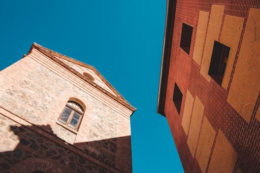 A low angle shot of architectural design of a building with a clear blue sky in the background