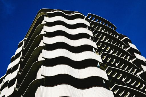 A low angle shot of a modern architectural building with a clear blue sky in the background