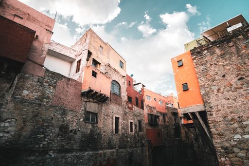 A low angle shot of old buildings of houses with a cloudy sky in the background