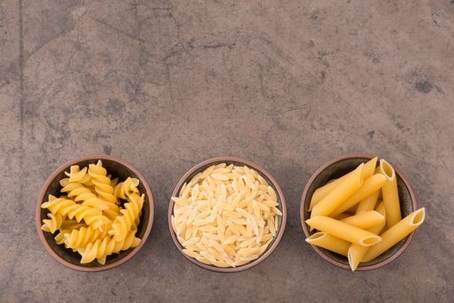 Different kinds of pasta on a textured background,ingredients for italian meal