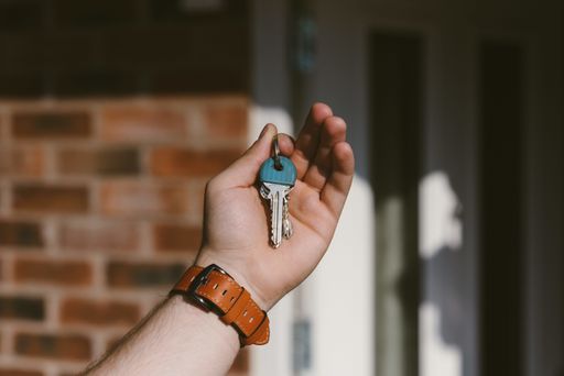 A closeup of a person hand holding keys with a blurred background