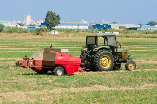 The hay baler tractor, an agricultural machinery, in the farm field of Fuengirola, Spain