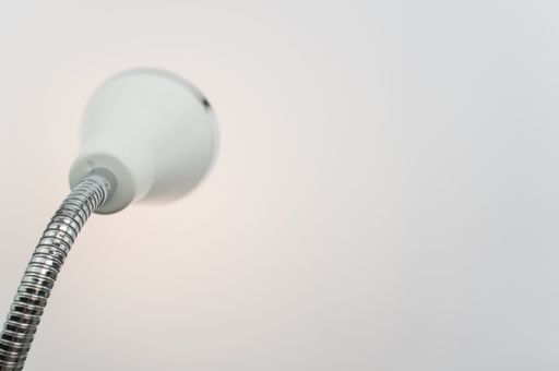A closeup shot of a metal desk lamp isolated on white background