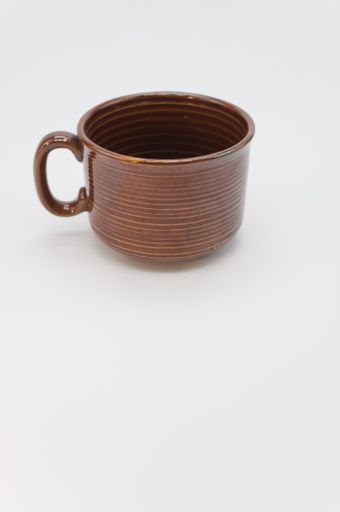 A vertical shot of a brown mug isolated on a white background