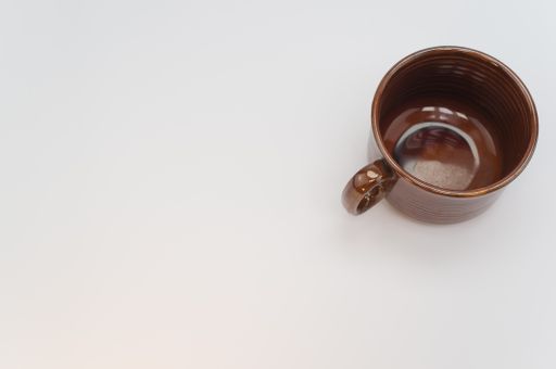 A high angle shot of a brown mug isolated on a white background
