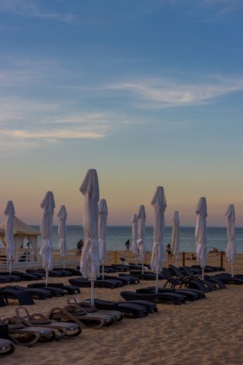 A vertical shot of beach beds and closed canopies on a sandy beach in Sopot, Poland
