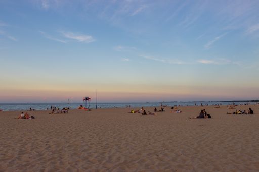 A shot of people laying and relaxing at a sandy beach in Sopot, Poland
