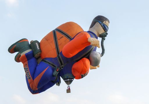 A close-up shot of a flying man-shaped hot air balloon at the Bristol Balloon Festival in the UK
