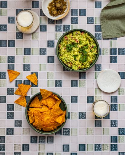 Guacamole with Nacho Crisps and Beer on Mosaic Surface