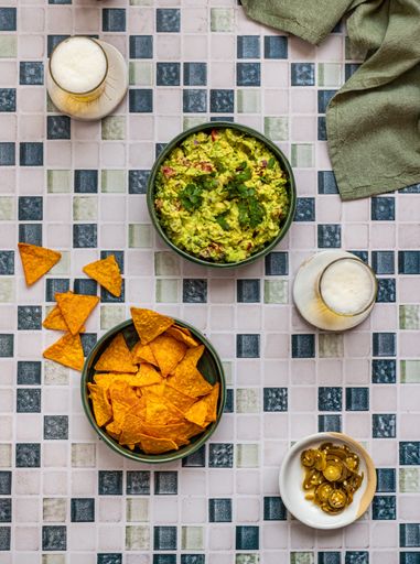 Guacamole with Nacho Crisps and Beer on Mosaic Surface