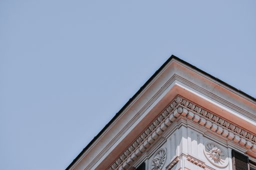 A low angle shot of a building corner detail in Rome against a blue sky