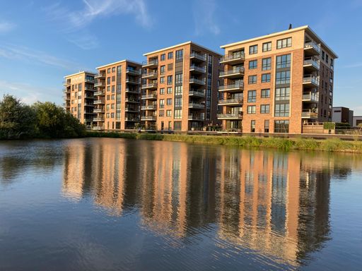 An apartment building complex in a new suburban area with the reflection on the water in Leide
