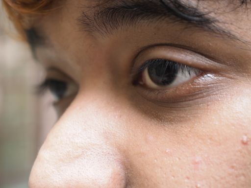 eye macro shot. Close-up of Asian teenage guy brown eye with looking straight to the target. Healthy life concept.