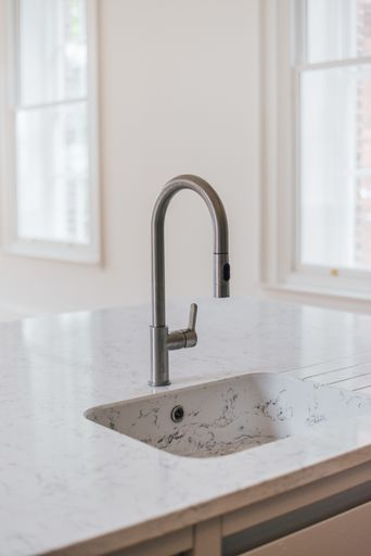A vertical shot of a white sink in the kitchen