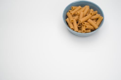 A top view of rigatoni pasta on a bowl isolated on white background