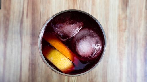 A top view shot of a glass filled with red wine on a wooden table