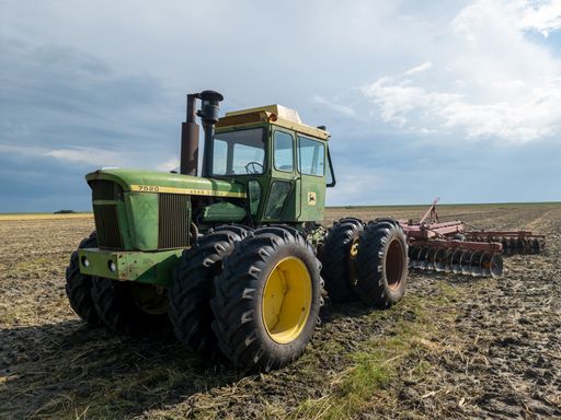 Big green John Deere tractor on a field