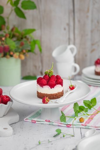 A Delicious chocolate cake topped with cream and fresh raspberries