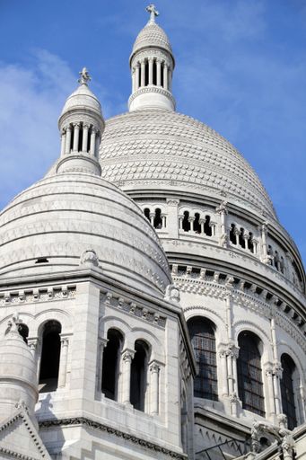 Close up of the Sacre Coeur Basilica domes against a clear blue sky in Paris, France.