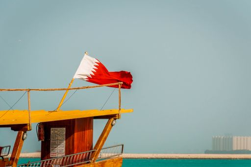 A closeup shot of a small boat with a flag in The Doha Corniche in Qatar, Doha
