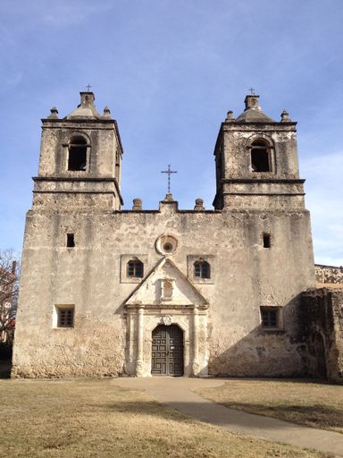 Historic Mission Concepcion in San Antonio, Texas, under a clear blue sky, showcasing Spanish colonial architecture.