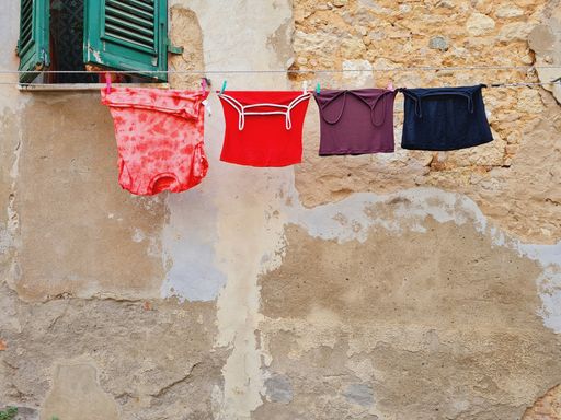 A colorful laundry hanging out to dry on a clothesline of an old building