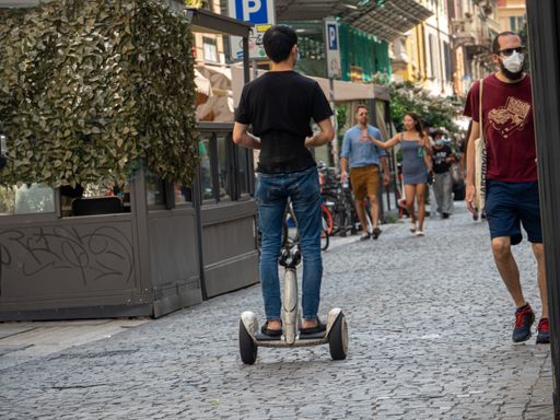 person rider electric scooter in the center of milano italy