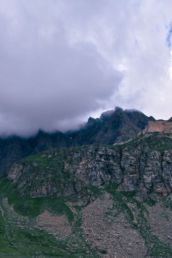 A vertical shot of the rocks covered by dense fog in the Gran Paradiso National Park in Italian Alps