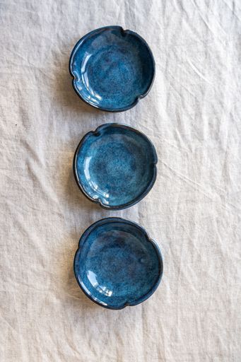 Handmade stoneware ceramics with various glazes on a soft cloth