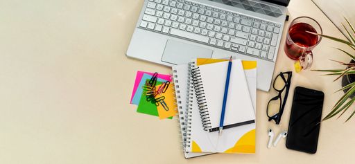 A top view of stationery with a text ''Back to school'' with glasses, phone and laptop on the desk