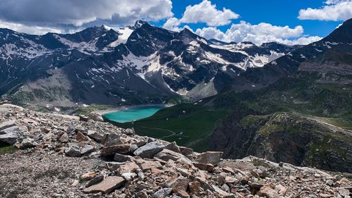 An aerial shot of a beautiful mountain range with a lake at the Gran Paradiso National Park in Italy