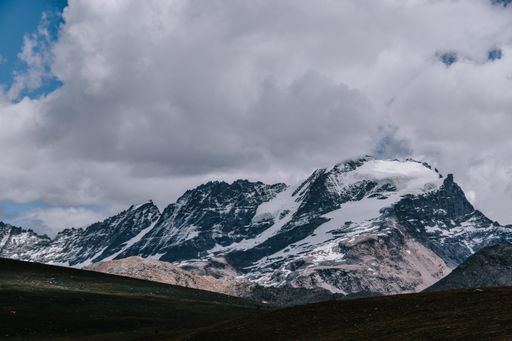 A snow-capped mountain range under a cloudy sky at the Gran Paradiso National Park in the Italian Alps