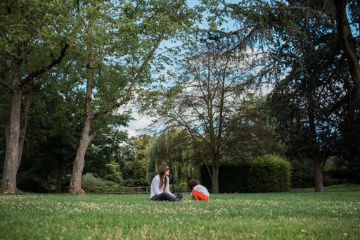 A young mixed-race female having fun with her daughter in the park
