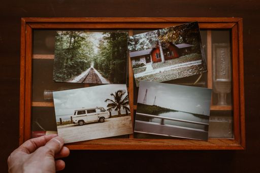 A shot of four random photographs of memories pinned on a wooden board