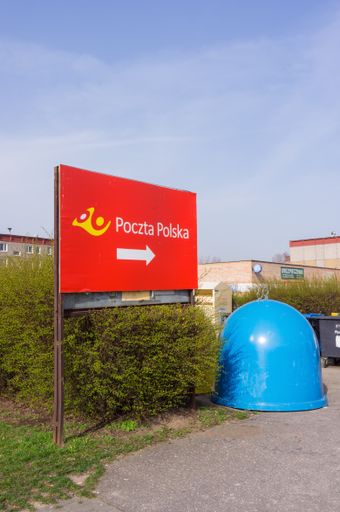 A vertical shot of a "Poczta Polska" sign showing the location of the post office in Poznan, Poland