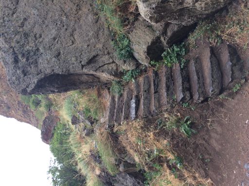 A vertical shot of a narrow stone staird on a mountain