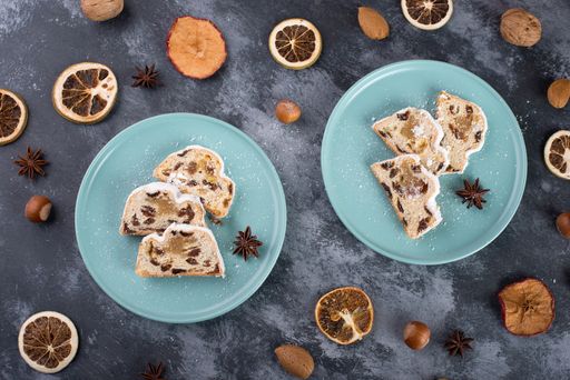 Christstollen, traditonal christmas cake with nuts, raisons, marzipan on a textured background, empty space for text