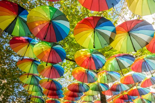The hanging rainbow umbrellas in the sky during the gay pride in the Marais district of Paris, France