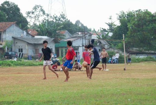 Some boys playing football on the field without wearing shoes