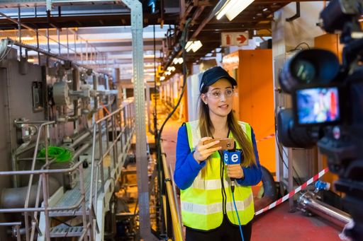 A female TV news reporter covering a live event in beer factory