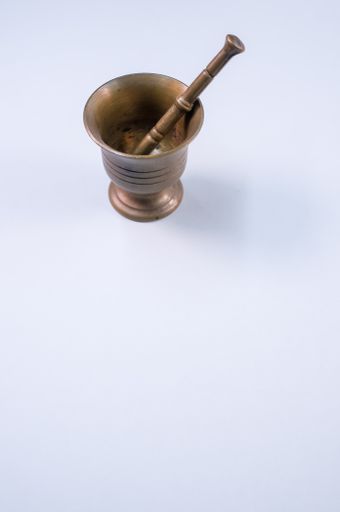 The vintage bronze mortar and pestle isolated on a white background with free space for text
