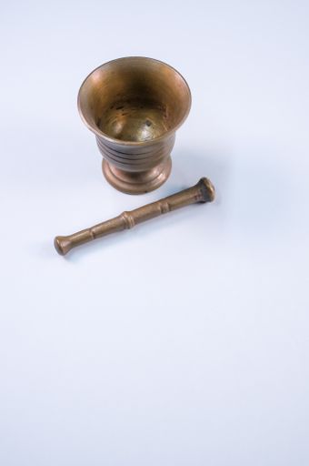 The vintage bronze mortar and pestle isolated on a white background with free space for text