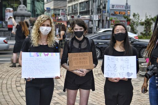 Young women holding posters and protesting during the Busan BLM protests in South Korea