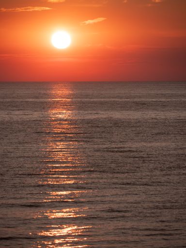 A vertical shot of the red sunset above the sea